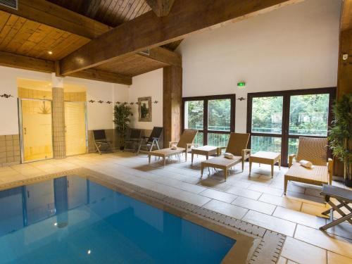 - une piscine dans une maison avec des chaises et une table dans l'établissement Gîte Alsacien : Terrasse, Sauna Privé, Accès Piscine et Bien-être, Proche Colmar et Route des Vins - FR-1-744-16, à Rouffach