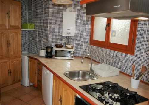 a kitchen with a sink and a stove top oven at La Salamandra in El Arenal