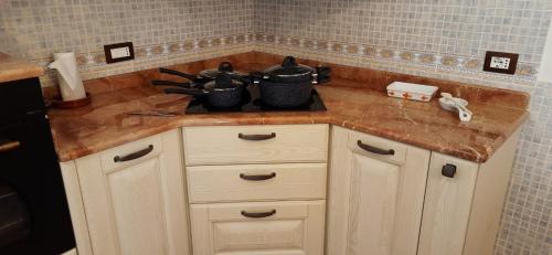 - un comptoir de cuisine avec des casseroles et des poêles dans l'établissement La Valle delle Rose, à Massafra