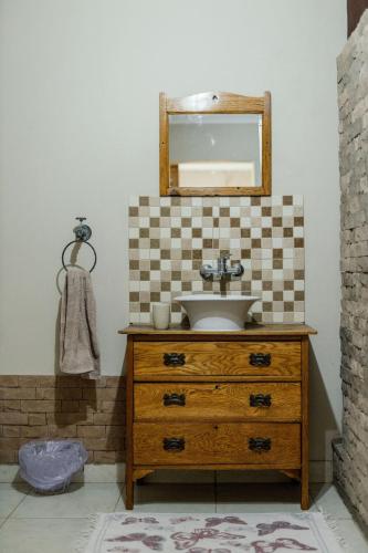 a bathroom with a sink and a mirror on a dresser at Elim Guesthouse in Keimoes