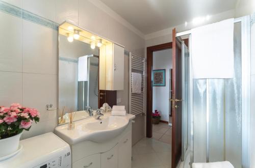 Baño blanco con lavabo y espejo en Casa Battaglia, en Cavallino-Treporti