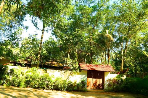 una pequeña casa en medio de un bosque en Marari John Villa, en Mararikulam