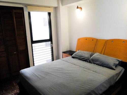 a bedroom with a bed with a blue pillow on it at Hermoso Apartamento Familiar in Caracas