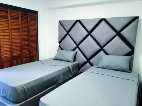 a bedroom with two beds and a headboard at Hermoso Apartamento Familiar in Caracas