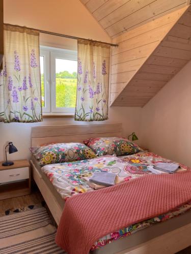 Bett in einem Zimmer mit Fenster in der Unterkunft Domek na Śmigowskim Piwniczna-Zdrój in Piwniczna-Zdrój