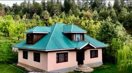 a house with a green roof on top of it at Country side cottage in Gulmarg