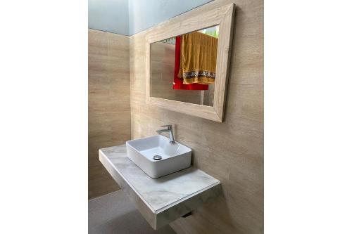 a bathroom with a sink and a mirror at OYO 93508 Bale Jiwan Mukti Narmada in Narmada