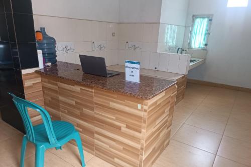 a kitchen with a counter with a laptop on it at OYO 93512 Umbuy Homestay in Rantau