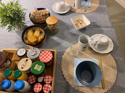 une table avec des assiettes, des tasses et de la vaisselle dans l'établissement Chambres Domaine de Laléard, à Saint-Hilaire-de-Villefranche