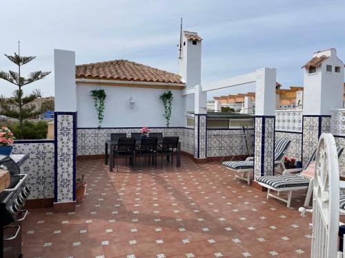 patio ze stołem i krzesłami na balkonie w obiekcie Holiday home with large roof terrace near La Mata beach w mieście Torrevieja