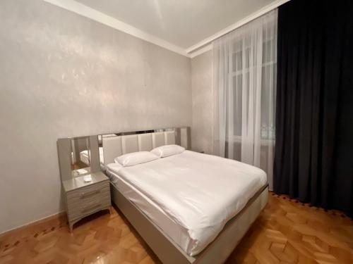 1 dormitorio con cama blanca y ventana en IT Hotel Yerevan, en Ereván