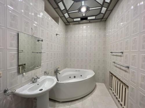 Baño blanco con bañera y lavamanos en IT Hotel Yerevan, en Ereván