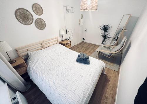 um quarto com uma cama branca e uma cadeira em Appartement unique et charmant au coeur du Vieux-Lille em Lille