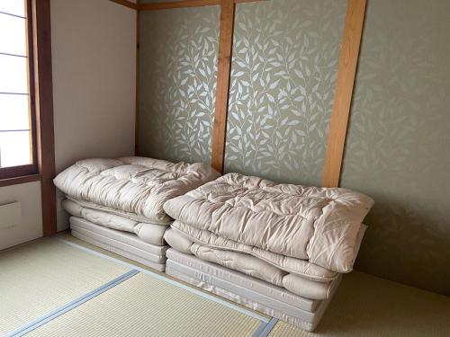 a bed sitting in a corner of a room at Lavender - Vacation STAY 26426v in Nishina