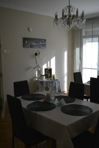 un comedor con una mesa con sillas y una lámpara de araña en Fehérvadász Vendégház, en Szombathely
