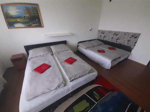 1 dormitorio con 2 camas con tarjetas rojas. en Fehérvadász Vendégház, en Szombathely