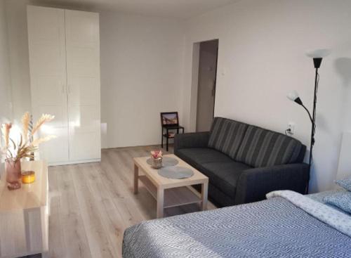 uma sala de estar com um sofá e uma mesa de centro em Modern studio apartment Baltijos em Klaipėda