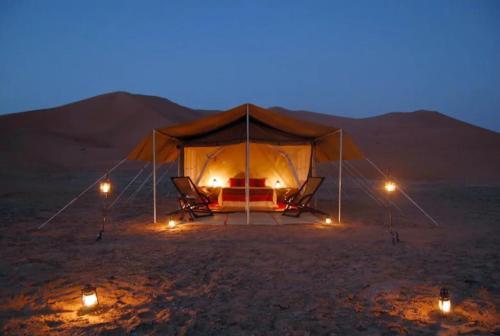 a tent in the middle of the desert at night at MBZ - Pleasant Tidy Room in Abu Dhabi