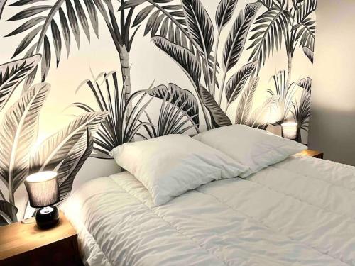 - une chambre avec un lit orné d'une fresque murale de palmiers dans l'établissement Entre plage et détente aux Conches, Maison avec terrasse et jardin privé, à Longeville-sur-Mer