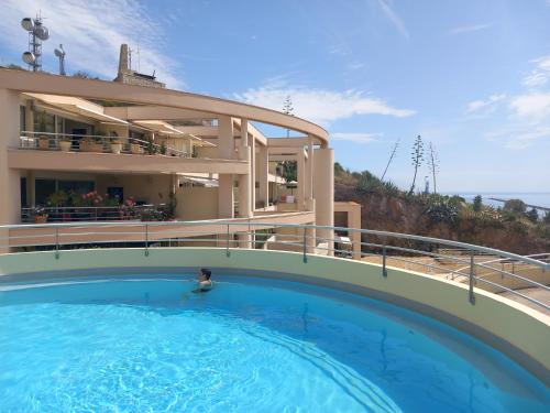 une grande piscine devant un immeuble dans l'établissement T3 vue mer - terrasse couverte, piscine, parking, proche du centre ville., à Sète