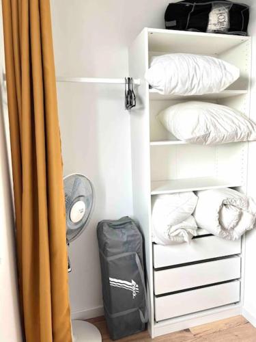 une étagère avec des oreillers et un sac dans la chambre dans l'établissement Entre plage et détente aux Conches, Maison avec terrasse et jardin privé, à Longeville-sur-Mer