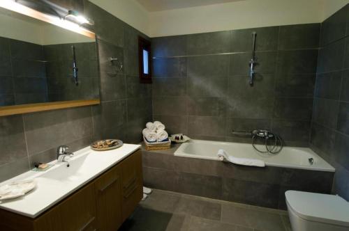 伊羅達的住宿－Elounda Blue Island Villa，带浴缸、盥洗盆和卫生间的浴室