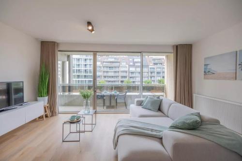 een woonkamer met een bank en een groot raam bij Mosselbank 211 in Nieuwpoort