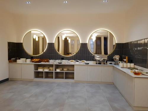デニズリにあるGrand Keskin Otelの壁掛け鏡3枚付きの部屋