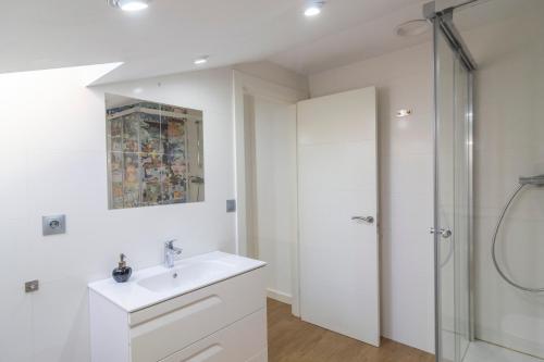 a white bathroom with a sink and a shower at APARTAMENTO HOLIDEA centro ciudad in Santander