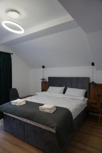 a bedroom with a large bed with towels on it at Pensiunea Cascada in Borşa