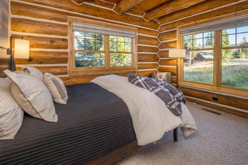 um quarto com uma cama num chalé de madeira em Powder Ridge Cabin | 6 Chief Gull em Big Sky