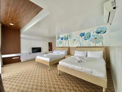 にあるArya Exclusive Villaのベッド2台とテレビが備わるホテルルームです。