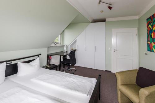 a bedroom with a bed and a chair and a desk at Villa La Cigale in Boltenhagen