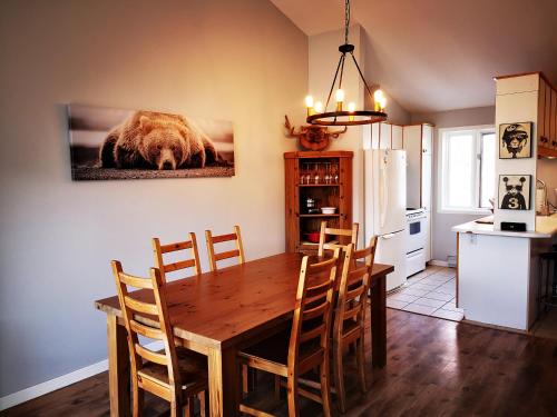 een keuken met een eettafel en een beer foto aan de muur bij Condo sur 2 niveaux avec magnifique vue sur la montagne in Stoneham