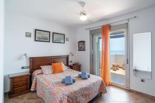 a bedroom with a bed and a sliding glass door at Ático en primera línea de playa con vistas al mar in Cala del Moral