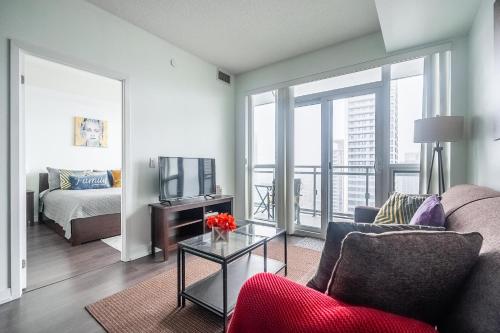 a living room with a couch and a tv at Modern Dunfield Ave Condos by GLOBALSTAY in Toronto