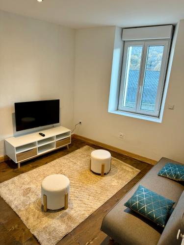 Charmant appartement في Serdinya: غرفة معيشة مع تلفزيون بشاشة مسطحة مع كرسيين