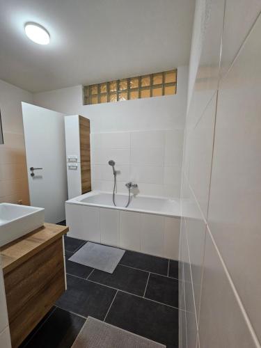 a bathroom with a tub and a sink at WernerS home in Sankt Florian bei Linz