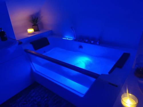 a blue room with a bath tub with lights in it at Sunny Family Residence with parking. Jacuzzi bath perfect for relaxing and unwinding in Kent
