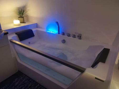 KentにあるSunny Family Residence with parking. Jacuzzi bath perfect for relaxing and unwindingのバスルーム(青い照明付きの白いバスタブ付)