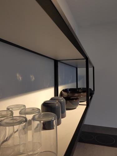 a row of clear glasses sitting on a counter at steenkamp•studio Auntys' Chamber in Hamburg