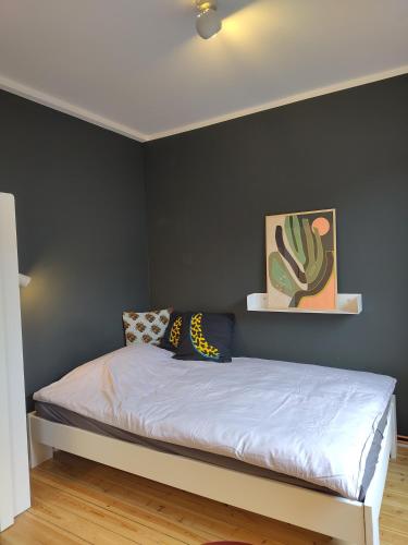 a bedroom with a bed with a black wall at steenkamp•studio Auntys' Chamber in Hamburg