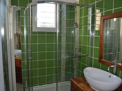 un bagno piastrellato verde con lavandino e doccia di VILLA face à la plage avec terrasse et jardin a Narbonne