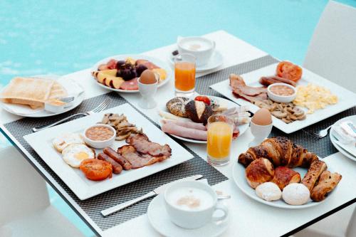 a table topped with plates of breakfast foods and drinks at Palazzo Violetta in Sliema