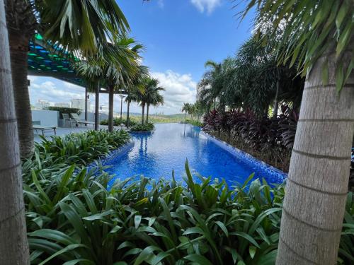 una piscina con palmeras en un complejo en CT View Homestay by Ifaizal, Presint 15 Putrajaya, en Putrajaya
