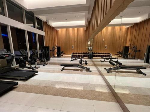 - une salle de sport avec plusieurs rangées de vélos d'exercice et de chaises dans l'établissement Apartemen Podomoro City Deli Park Medan, à Medan