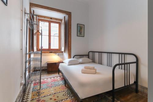 sypialnia z łóżkiem w pokoju z oknem w obiekcie Downtown Vintage Suites by Homing w Lizbonie