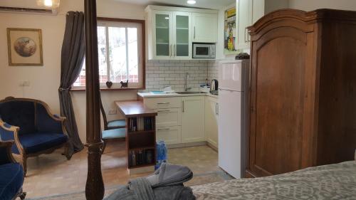 a kitchen with a bed and a refrigerator and a table at Jerusalem View in Mevasseret Zion