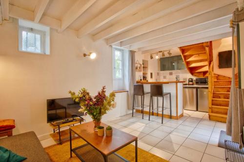 uma sala de estar com uma mesa e uma cozinha em The castle house em Caen