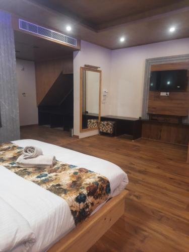 a bedroom with a large bed and a large window at Manali mountain River Hotel & Resort in Manāli